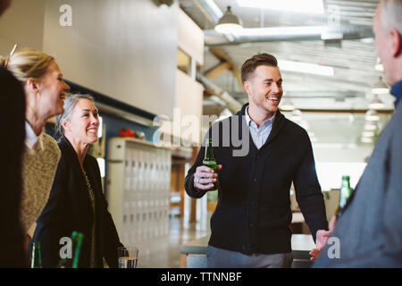 business people talking while enjoying drinks in office Stock Photo