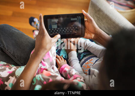 Overhead view of father using tablet computer with children at home Stock Photo