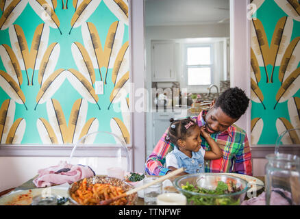 Father talking to daughter at dining table Stock Photo