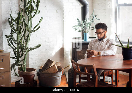 Young man using smart phone at home Stock Photo