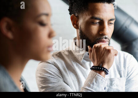Thoughtful young man by woman at home Stock Photo