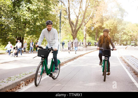 Happy couple riding bicycle in park Stock Photo