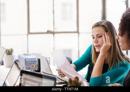 businesswomen discussing over documents at office Stock Photo
