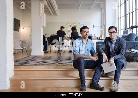 Portrait of serious business people with digital tablet sitting in office Stock Photo