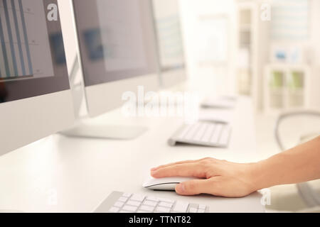 Female hand holding mouse while working on computer Stock Photo