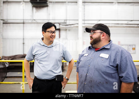 workers discussing while standing in Steel industry Factory Stock Photo