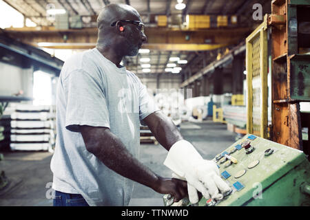 Manual worker using control machine while working in steel industry Stock Photo
