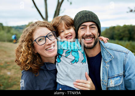 Portrait of happy family standing at orchard Stock Photo