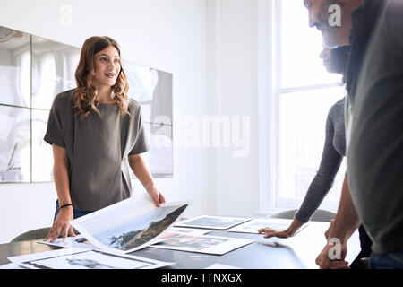 business people examining photograph printouts in board room Stock Photo