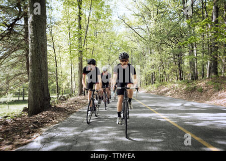 Cyclists riding bicycles on country road Stock Photo