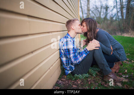 Side view of couple kissing in backyard Stock Photo