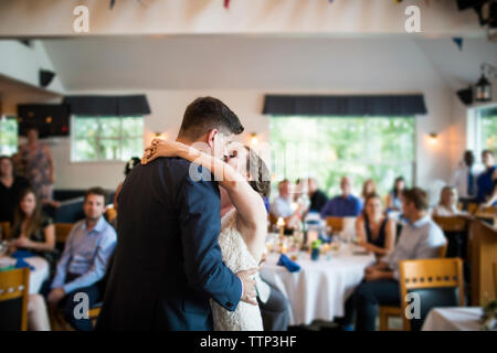 Newlywed couple kissing while dancing in wedding ceremony at restaurant Stock Photo