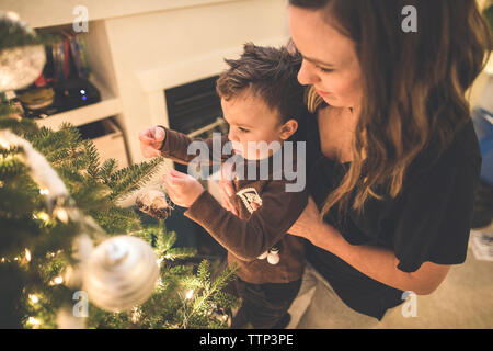 Mother and son decorate the family Christmas Tree Stock Photo