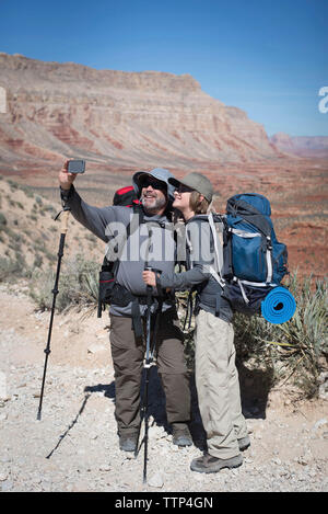 Man taking selfie with son while standing on land Stock Photo