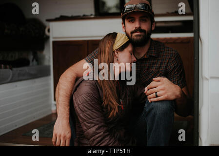 Girlfriend sleeping on boyfriend's chest while sitting in motor home Stock Photo