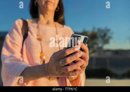 Midsection of woman using smart phone Stock Photo