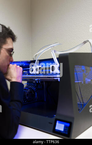Male engineer operating 3D printer on table in office Stock Photo
