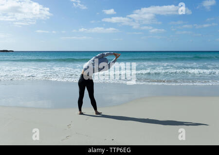 Asian woman stretching on the beach in the morning Stock Photo