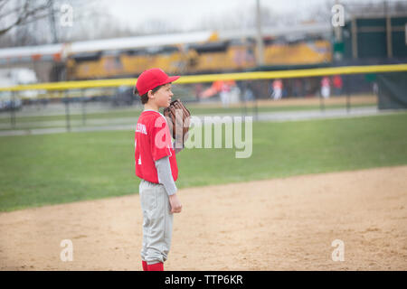 Side view of boy playing baseball at sports field Stock Photo