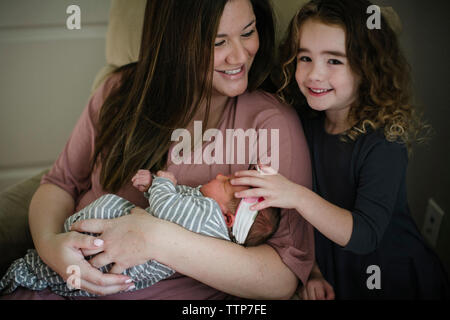 Portrait of smiling girl with mother and sister at home Stock Photo