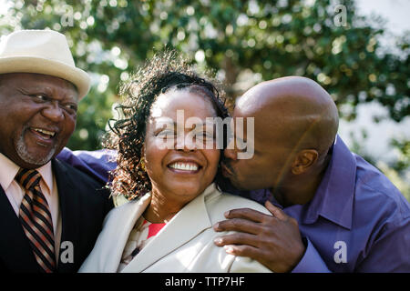 Close-up of father looking at son kissing mother in park Stock Photo