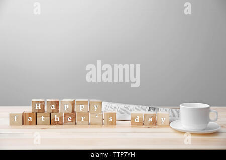 Words on cubes HAPPY FATHER'S DAY  and cup on light background Stock Photo