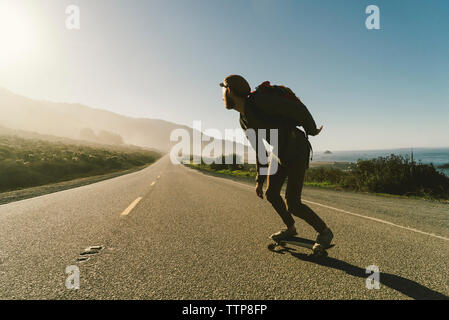 Full length of man skateboarding on country road Stock Photo