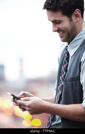 Happy businessman using smart phone on sunny day Stock Photo