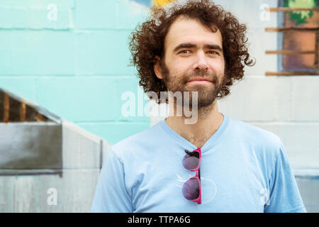 Portrait of smiling man standing against wall Stock Photo