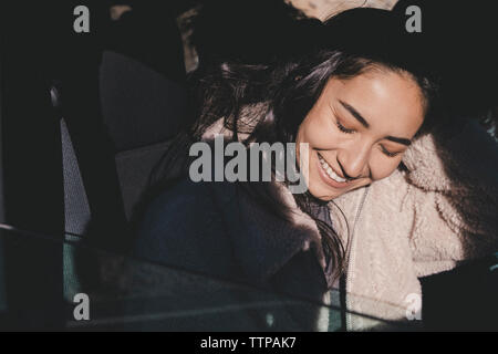 Close-up of cheerful young woman sitting in off-road vehicle during sunny day Stock Photo