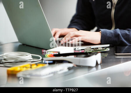 Midsection of male student using laptop at table Stock Photo