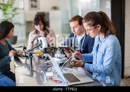 Students working with electrical equipment at table in classroom Stock Photo