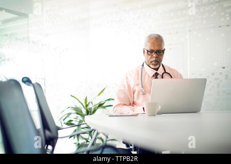 Doctor working on laptop computer in hospital Stock Photo