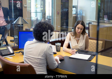 businesswomen discussing about document at desk in office Stock Photo