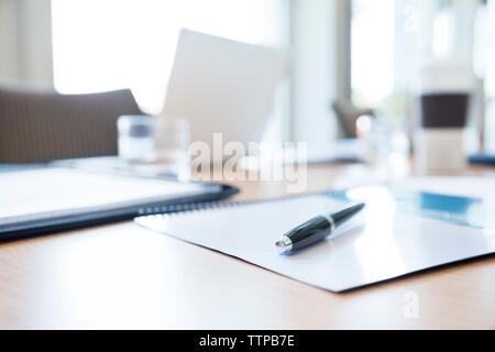 Note pad and pen by tablet computer on table in conference room Stock Photo