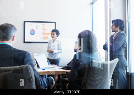 businesswoman giving presentation to colleagues in conference room Stock Photo