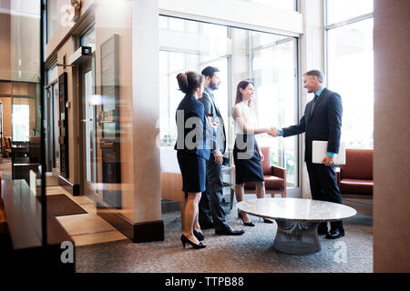 business people shaking hands at office lobby Stock Photo