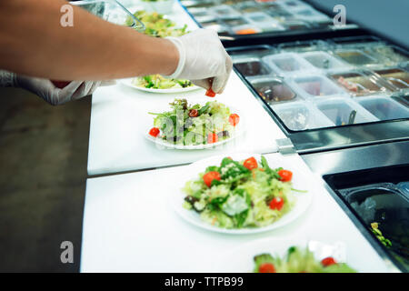Cropped image of chef serving food in commercial kitchen Stock Photo