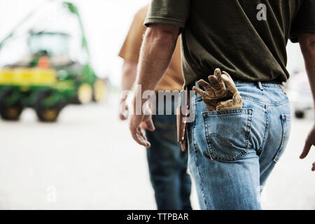 Midsection of farm workers walking at field Stock Photo