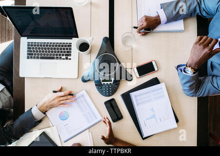 High angle view of business people analyzing reports in board room Stock Photo