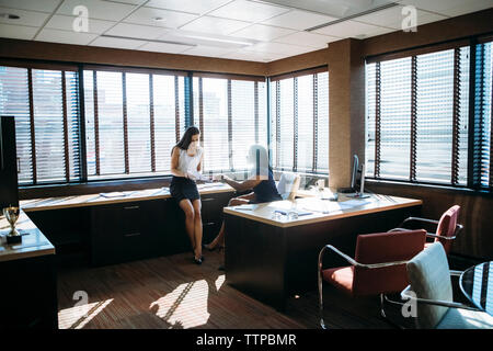 Female colleagues discussing reports in office Stock Photo