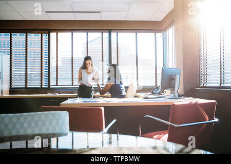 businesswomen discussing reports in office Stock Photo