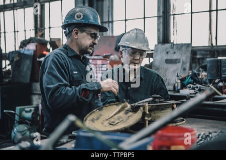 Coworkers working at table in metal industry Stock Photo
