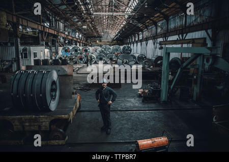 High angle view of male worker standing against steel sheets in factory Stock Photo