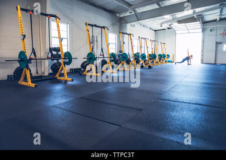 Woman stretching arms and legs while exercising in gym Stock Photo