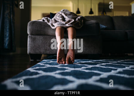 Low section of boy leaning on sofa at home Stock Photo