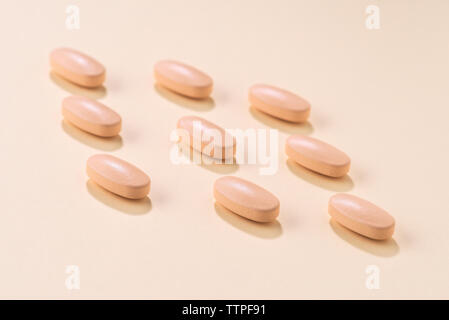 High angle view of medicines arranged on peach background