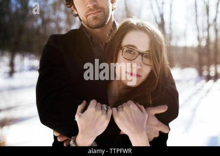 Midsection of man embracing woman during winter Stock Photo