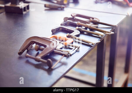 High angle view of various clamps on table at workshop Stock Photo