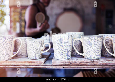 Various clay cups on shelf at workshop Stock Photo